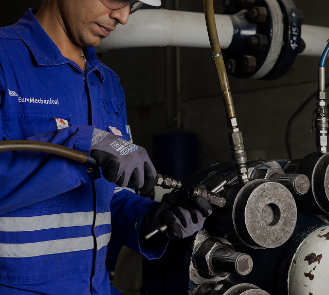 Technician performing controlled bolting on industrial flange